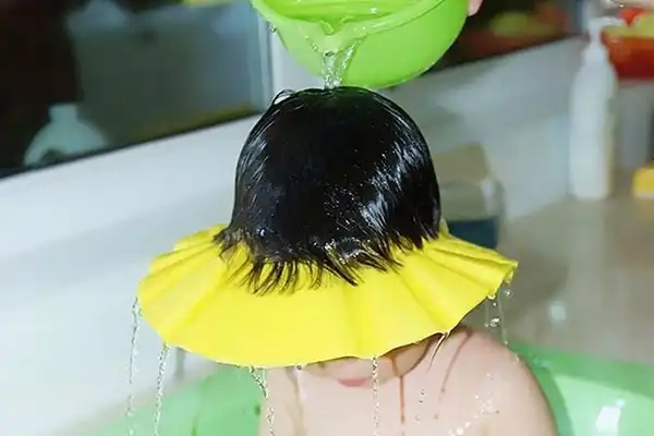 کلاه حمام از تماس آب با صورت کودک جلوگیری می‌کند.