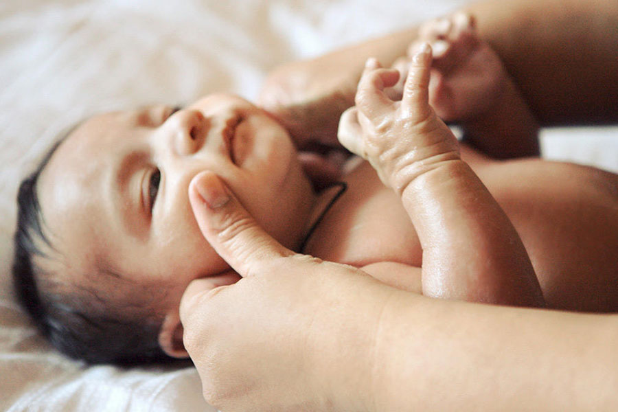 با حرکات آرام و دایره‌ای، روغن را به‌آرامی روی پوست نوزاد بمالید.